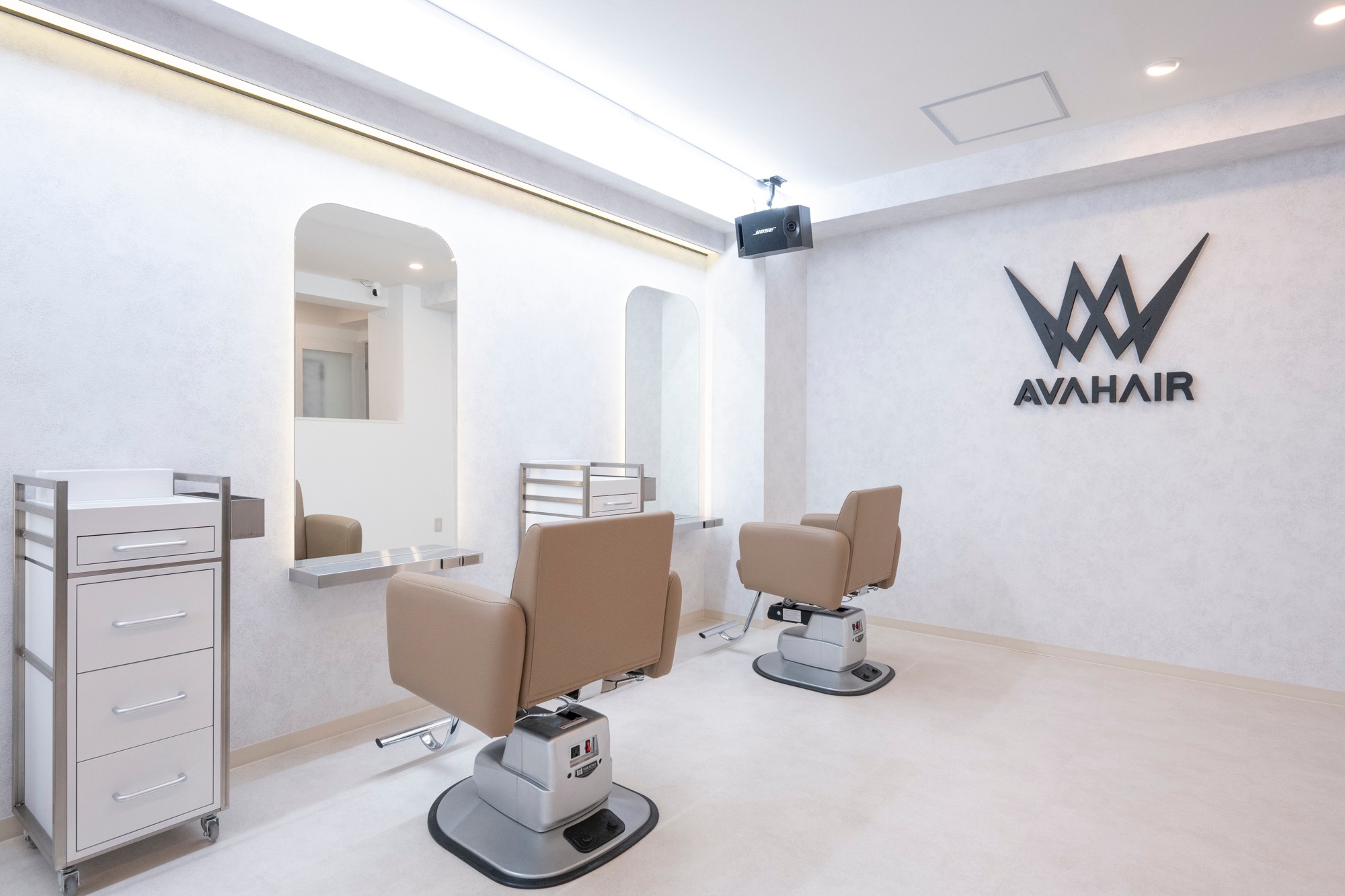 AVA HAIRの施術席とウォールロゴ